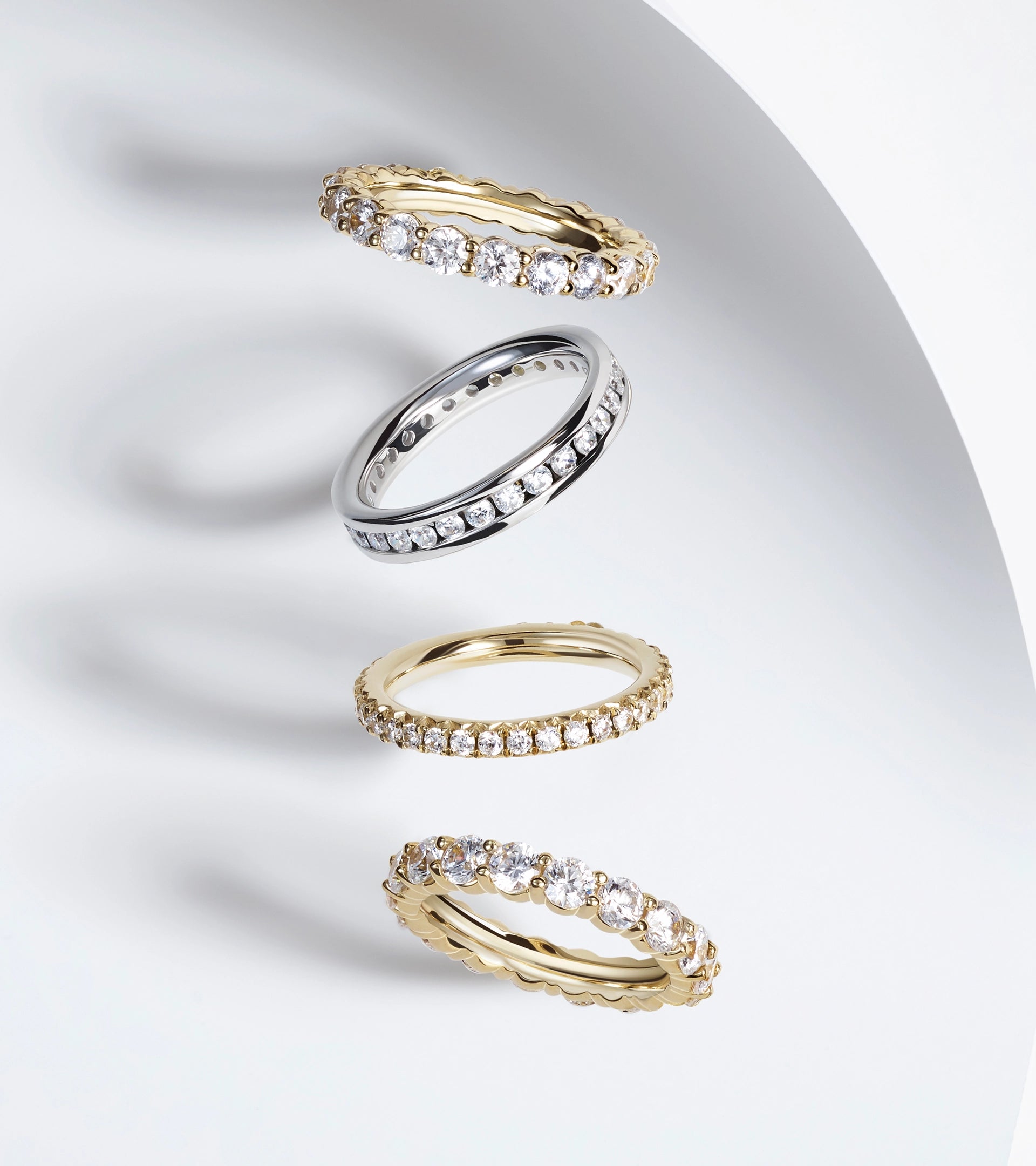 Four stacked ALTR lab-grown diamond eternity bands in yellow and white gold showing consistency.