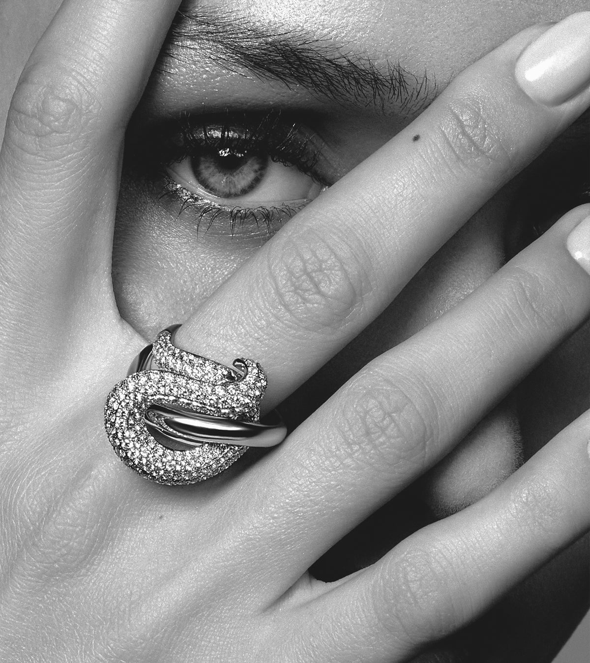 Close-up of a model wearing an intricate ALTR Couture lab-grown diamond pavé ring with a bold, sculptural design.
