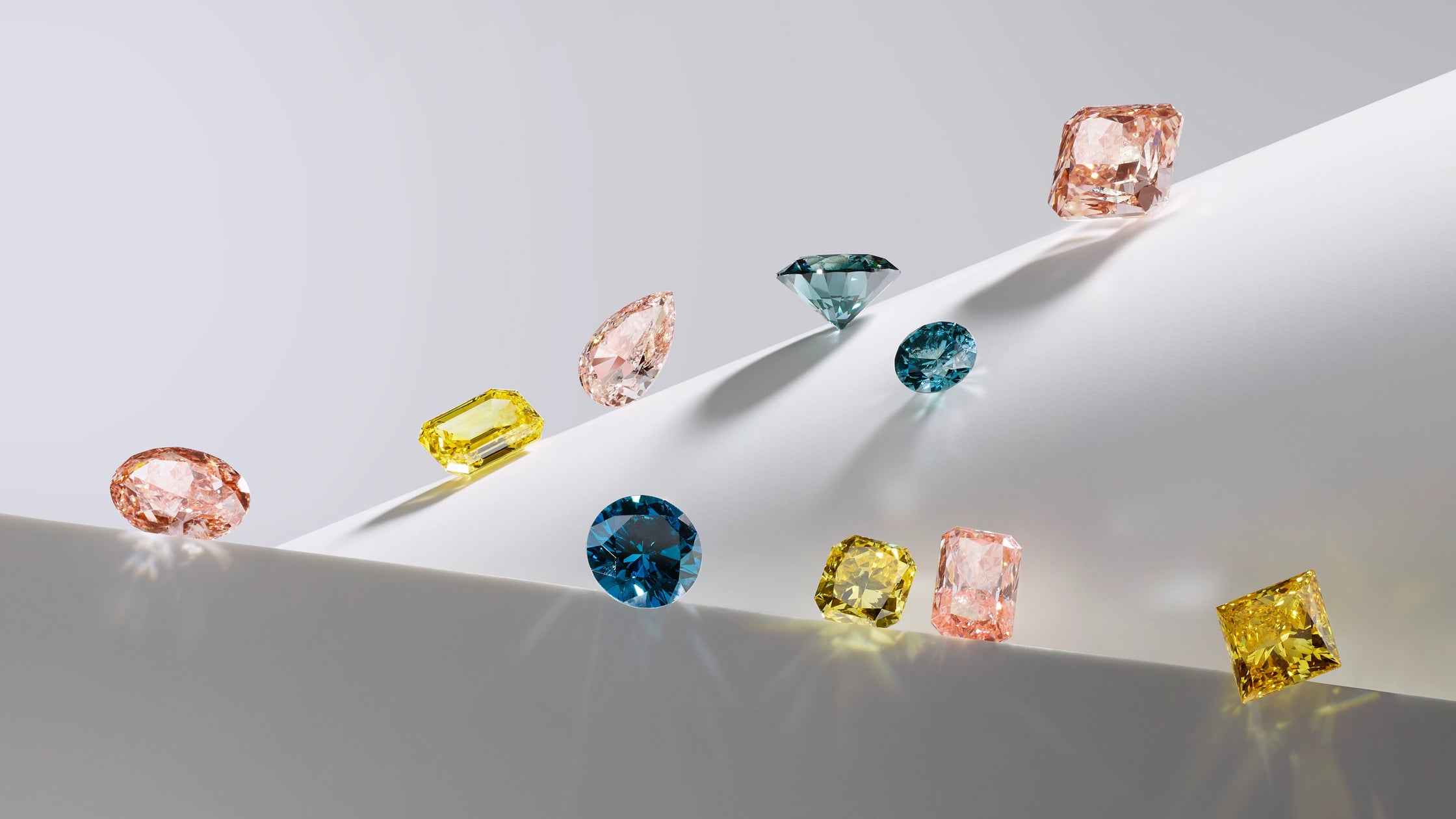 A creative display of fancy colored lab-grown diamonds, including pink, yellow, and blue stones in various shapes like pear, emerald, and radiant cuts. This high-resolution banner showcases the "Creativity" of ALTR’s lab-grown technology and the vibrant color possibilities of Type IIa diamonds.