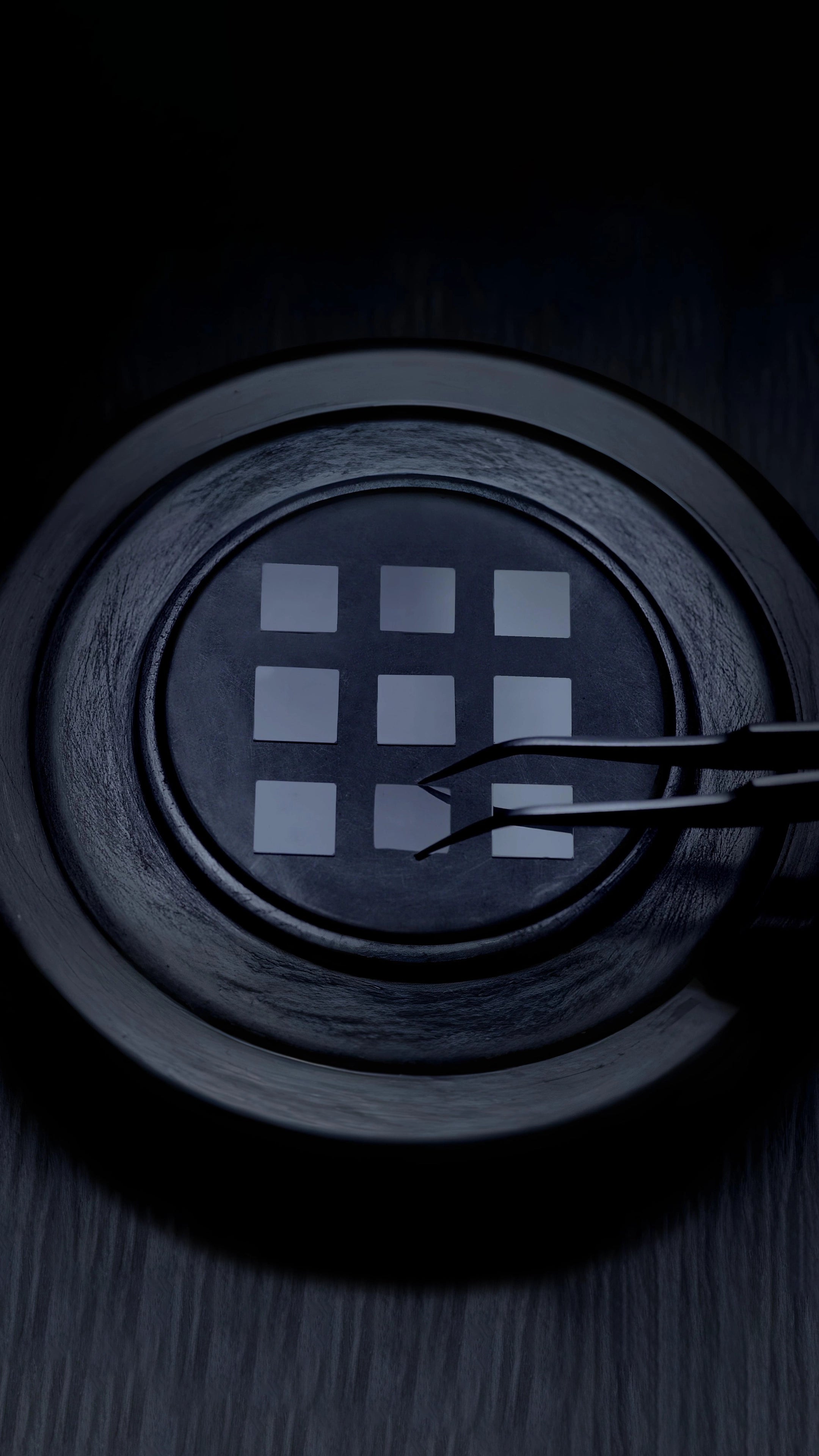 Tweezers placing square lab-grown diamond seeds onto a tray of the diamond growing chamber for the ALTR diamond creation process.
