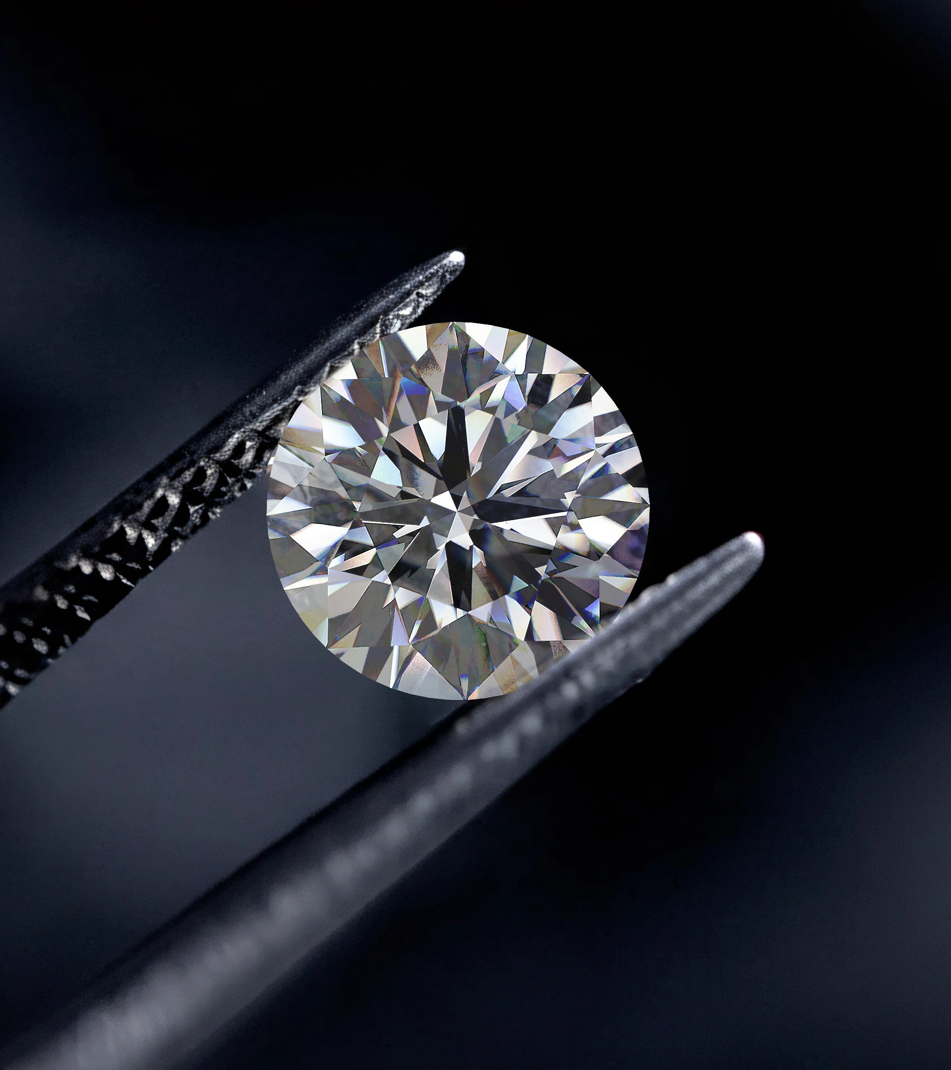 Tweezers holding a finished brilliant round-cut ALTR lab-grown diamond showing ideal facet symmetry.