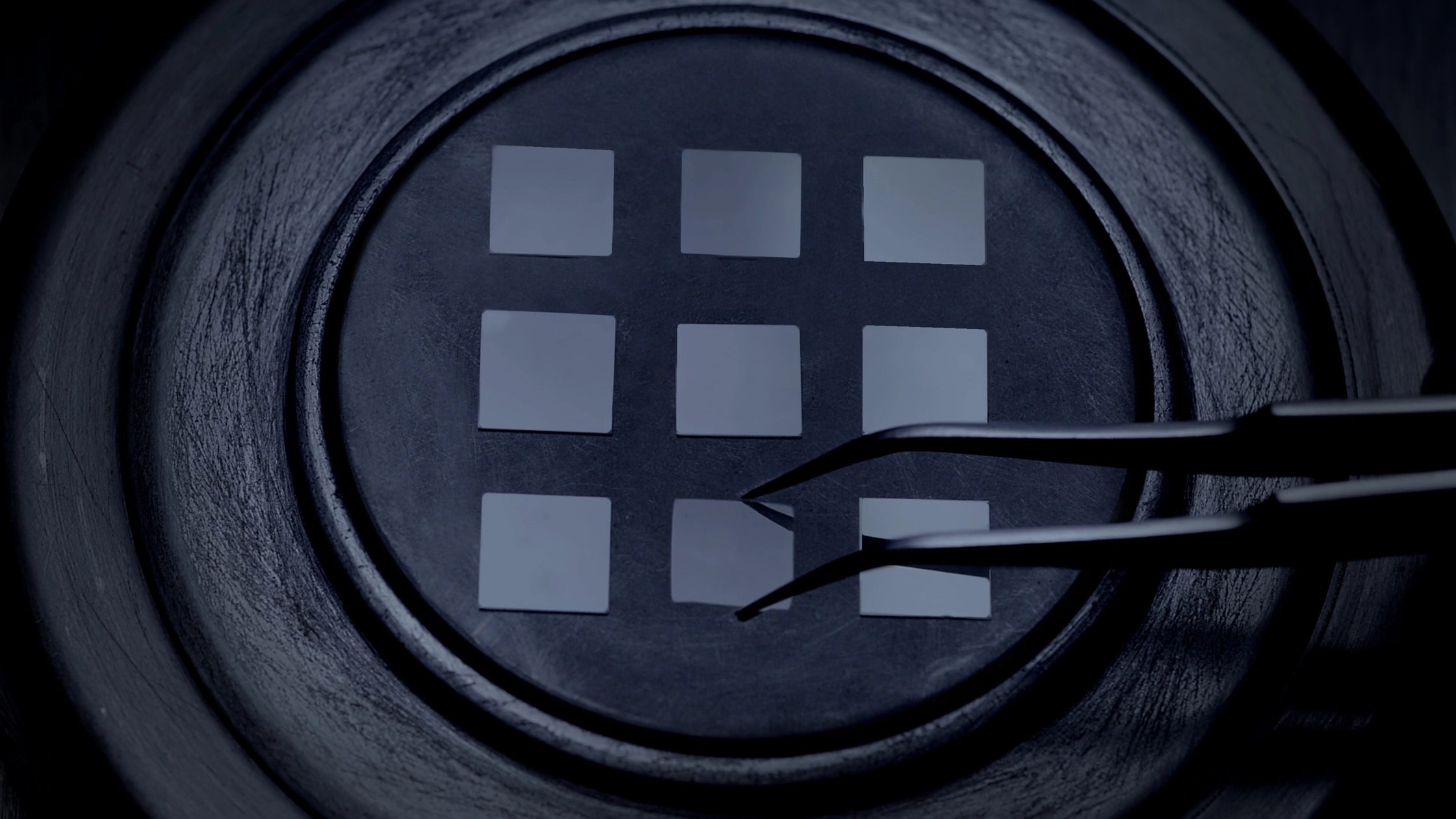 Tweezers placing square lab-grown diamond seeds onto a tray of the diamond growing chamber for the ALTR diamond creation process.