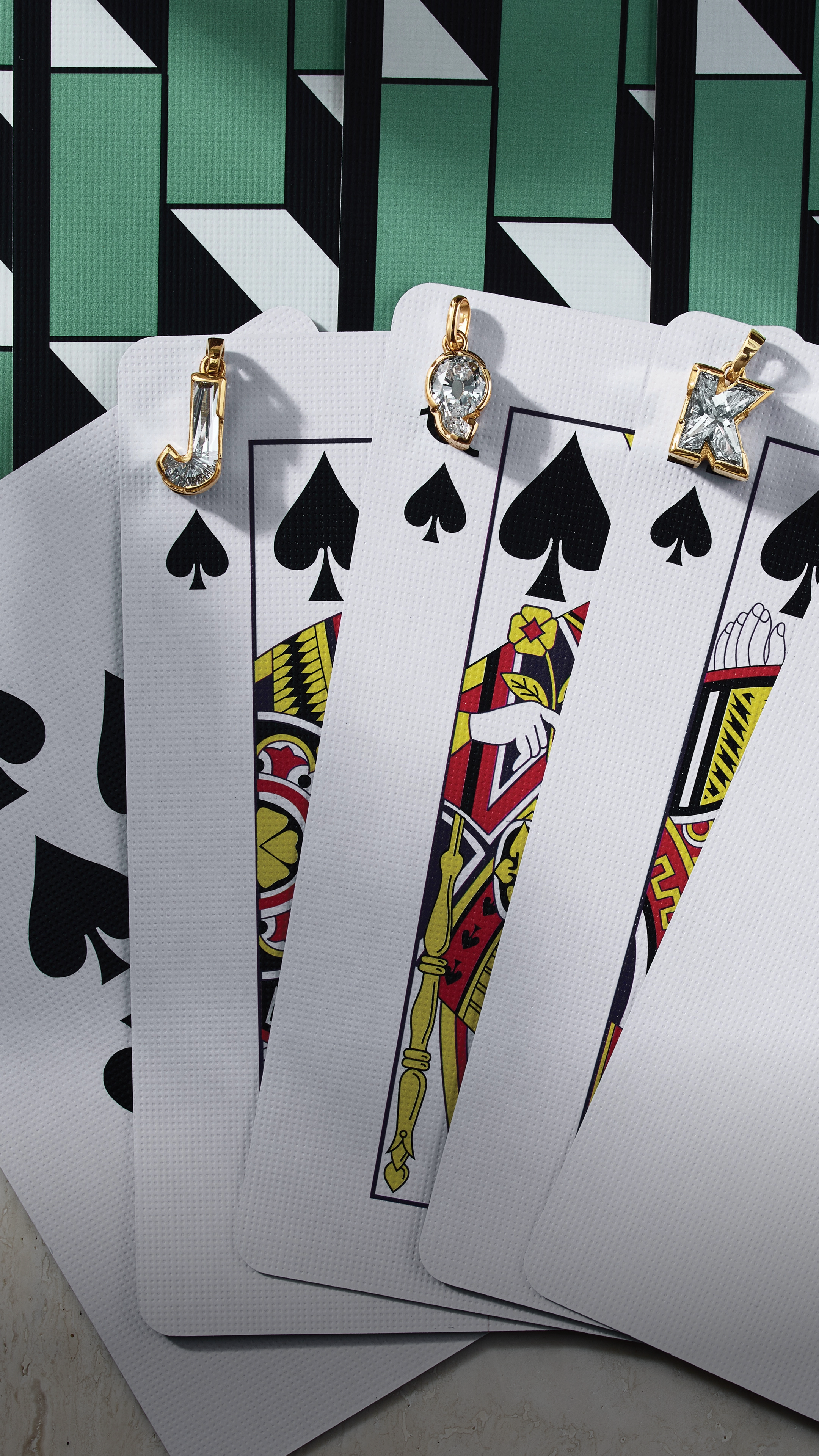 J’evar by ALTR "TYPE" collection display featuring a deck of cards aesthetic to showcase the world's first solitaire alphabet diamond initials. Each card represents a unique hand-cut diamond letter, born from a single Type IIa lab-grown stone. This creative visual highlights the intersection of architectural Art Deco design and sustainable luxury jewelry.