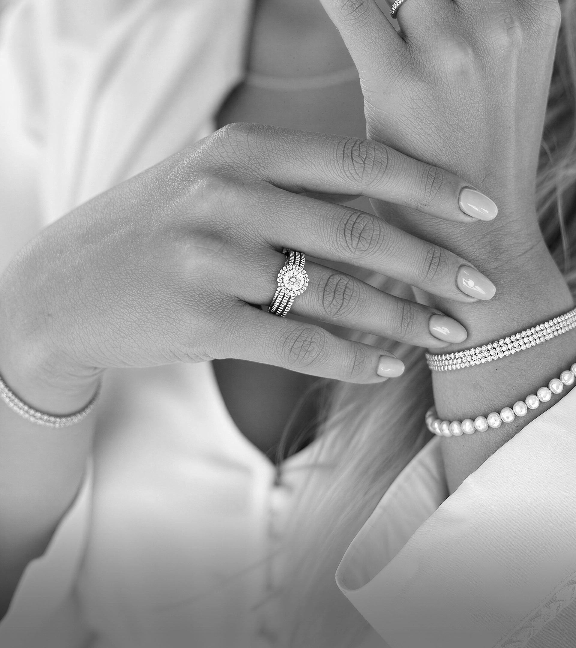 Model wearing an ALTR halo lab diamond engagement ring, stacked diamond bracelets, and a bracelet.