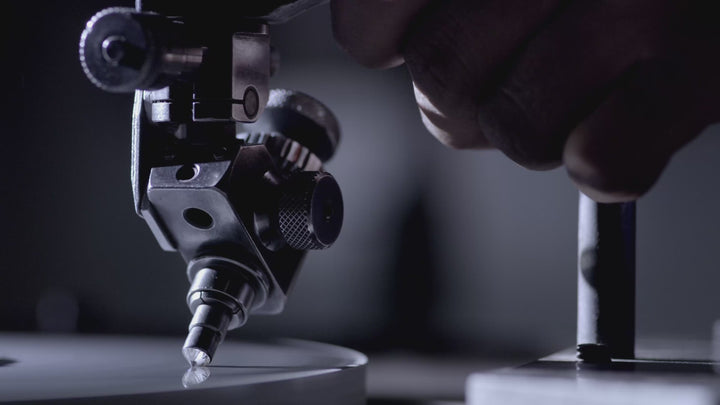 A cinematic montage of the diamond manufacturing process at ALTR. The video features the laser-cutting of a Type IIa diamond crystal, the grinding of the pavilion and crown facets on a diamond polishing wheel (scaife), and the final inspection of a polished, high-clarity brilliant diamond.
